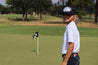 A young boy is wearing Willie Kids from Zilker Belts on a golf course.